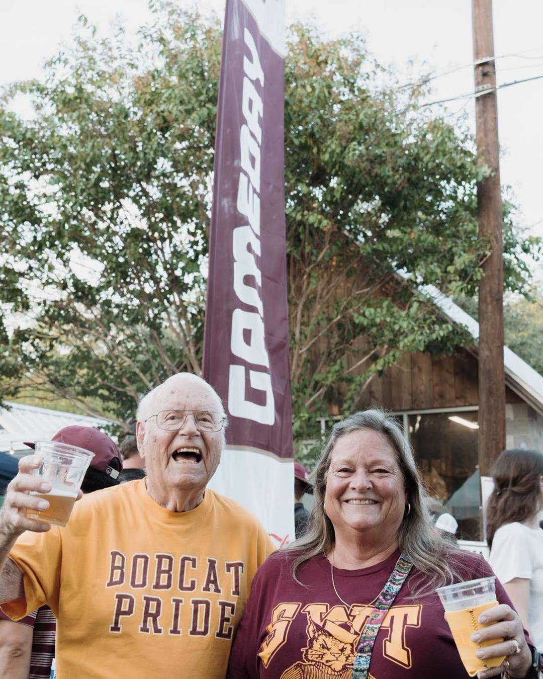 Two Texas State fans at an outdoor social event in Downtown San Marcos