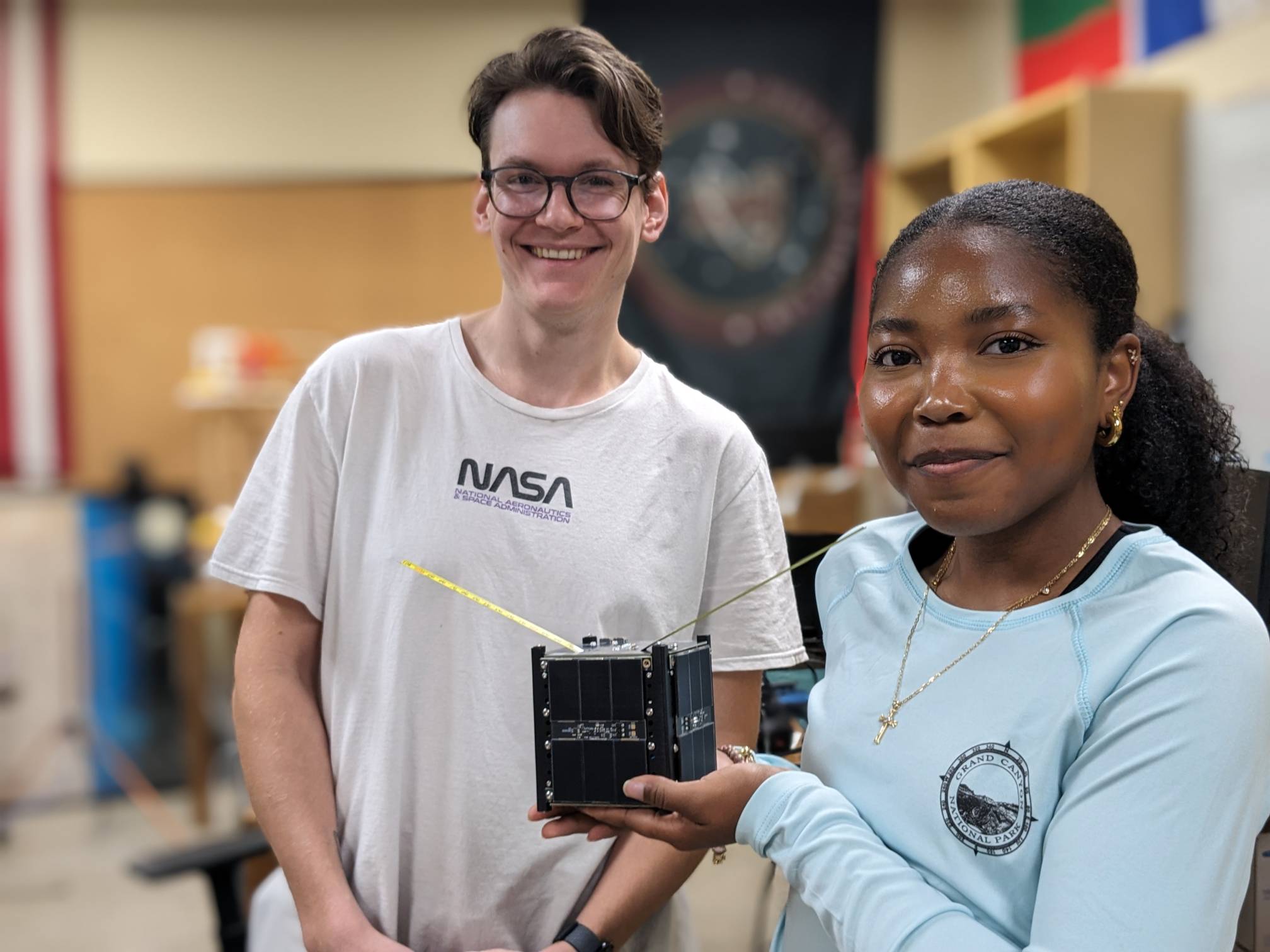 woman holding small black box while a man smiles next to her
