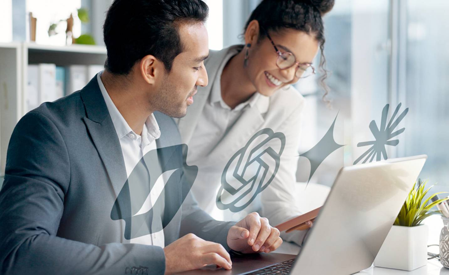 two people looking at a laptop on a desk