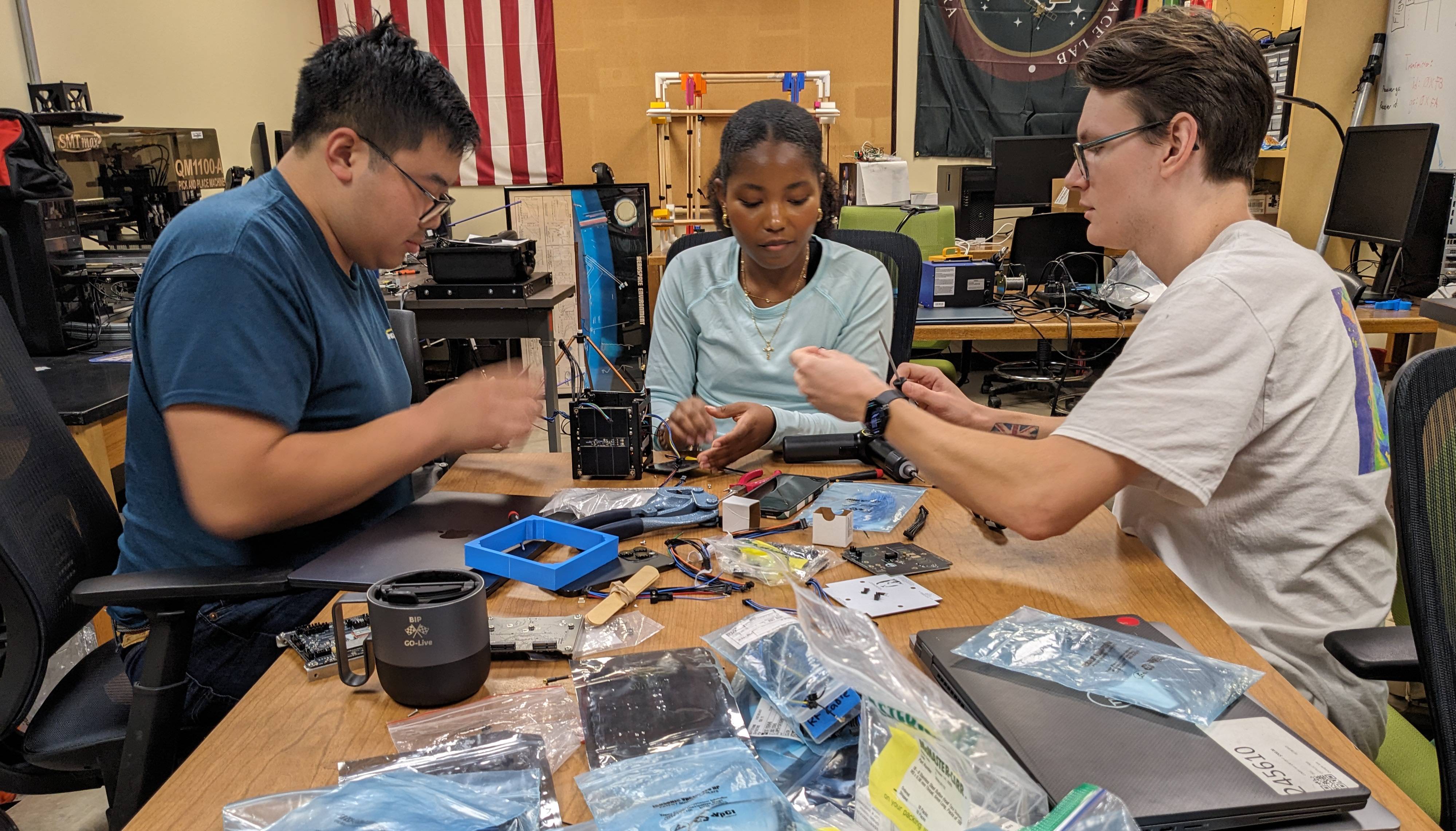 multiple students working on electronic in lab setting
