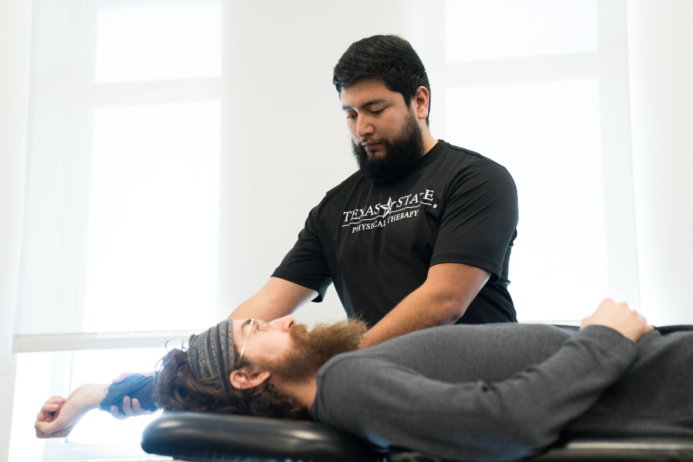 A Physical Therapy student is assisting a patient.