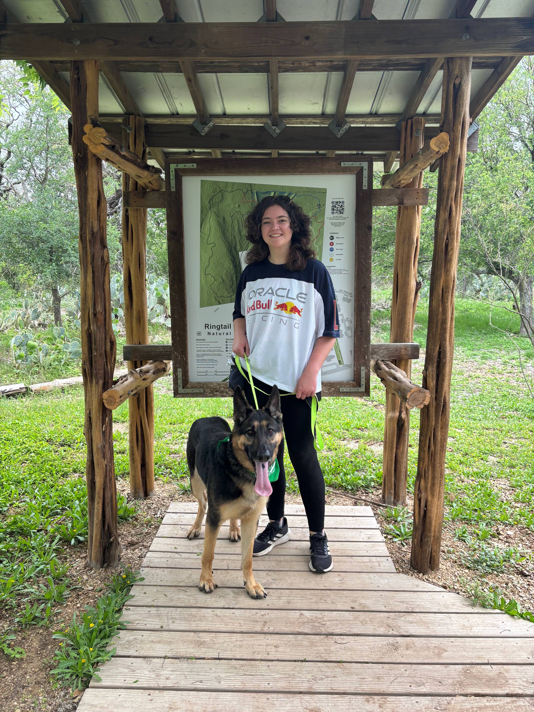 woman posing with german Shepard under wooden shelter