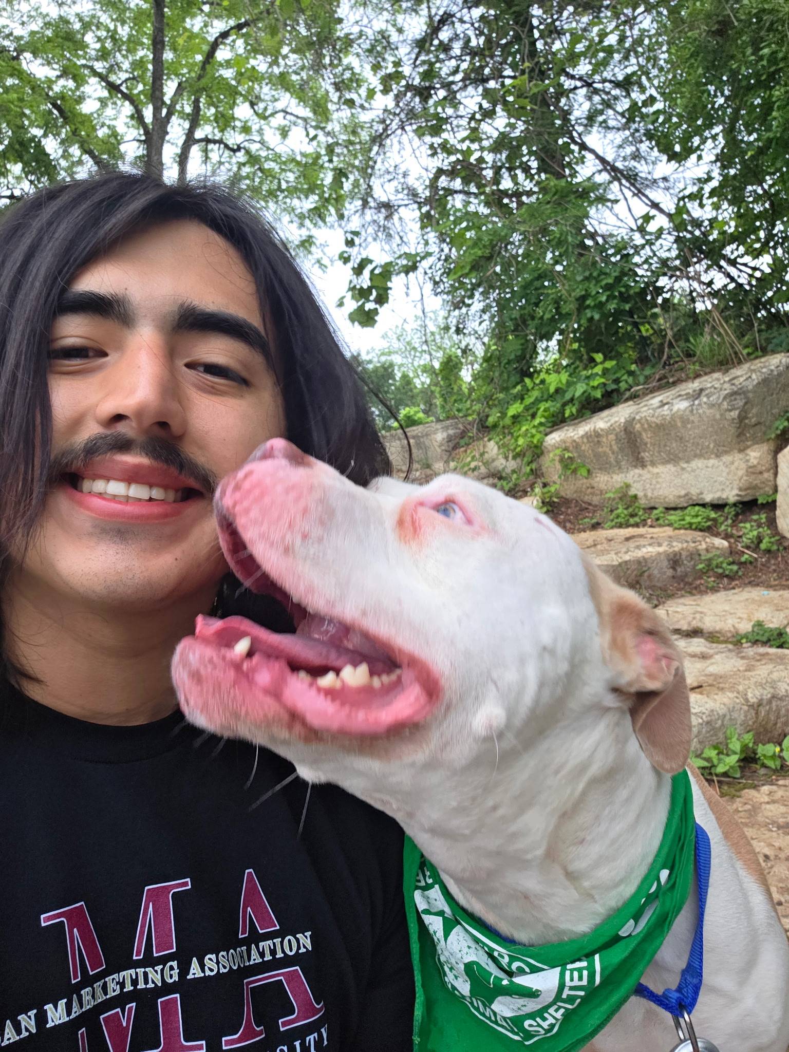 man taking selfie with white pitbull