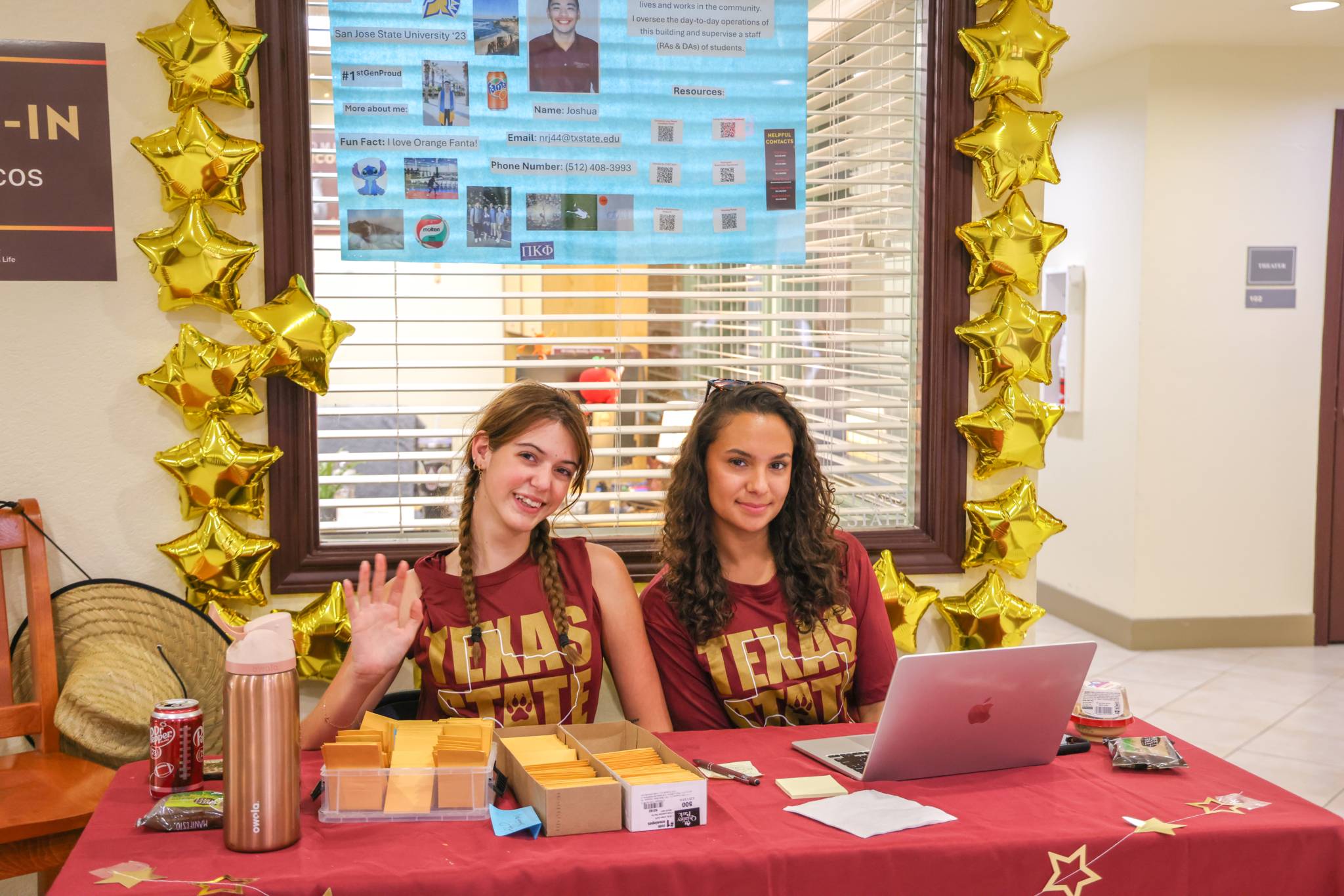Two female RAs at a check-in table during move-in.