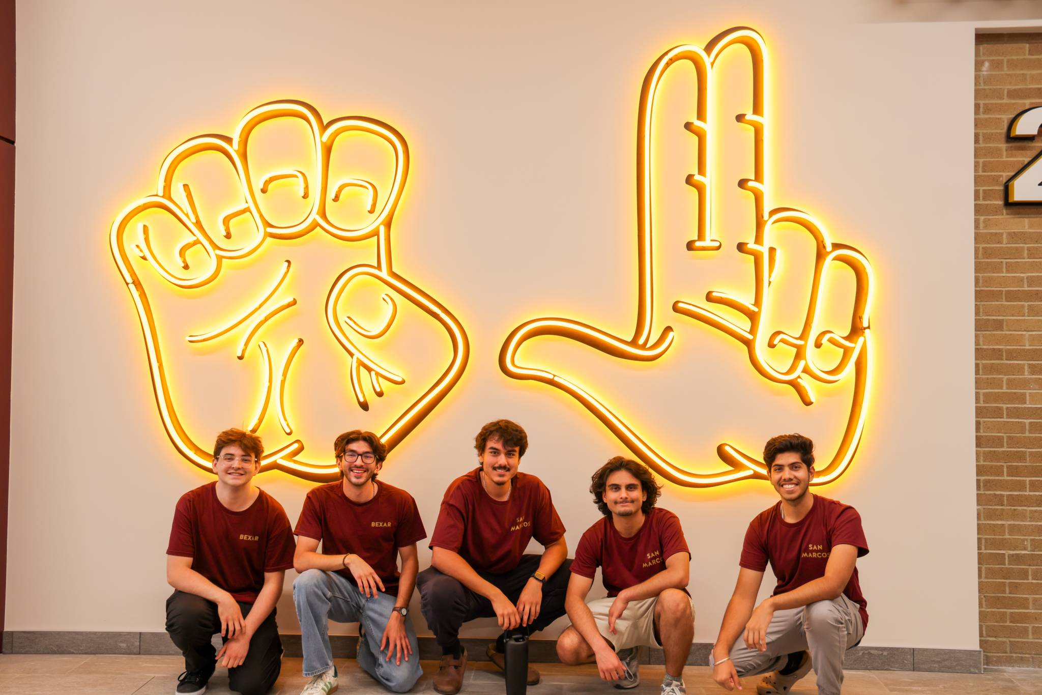 Group of RAs in front of the states up neon sign.