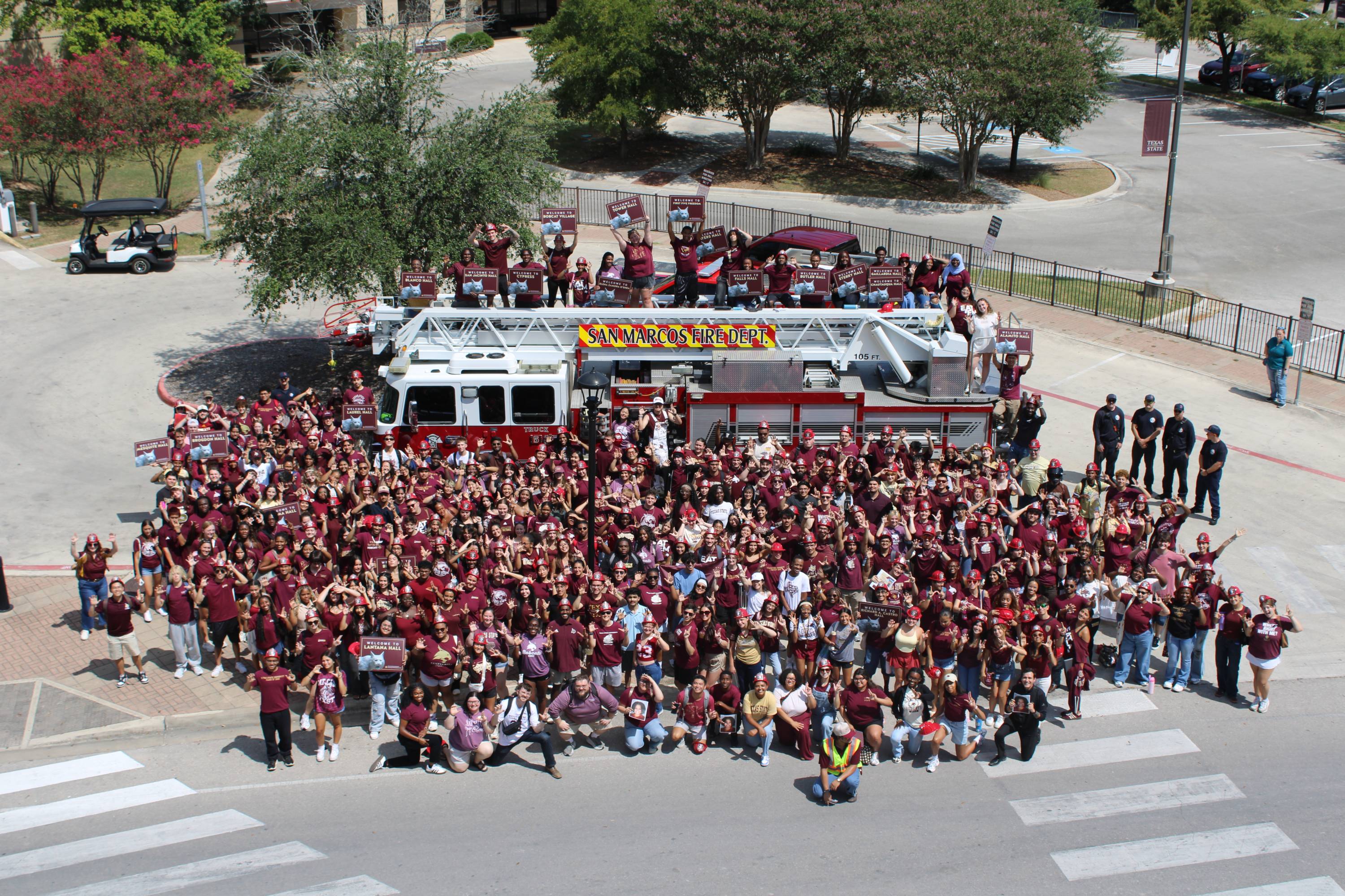 Hundreds of students in front of a fire truck.