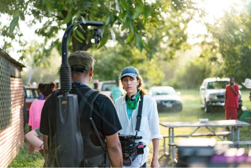 Filmmaker Annie Silverstein on the outdoor film set of Bull, standing next to a crew member wearing a camera harness.
