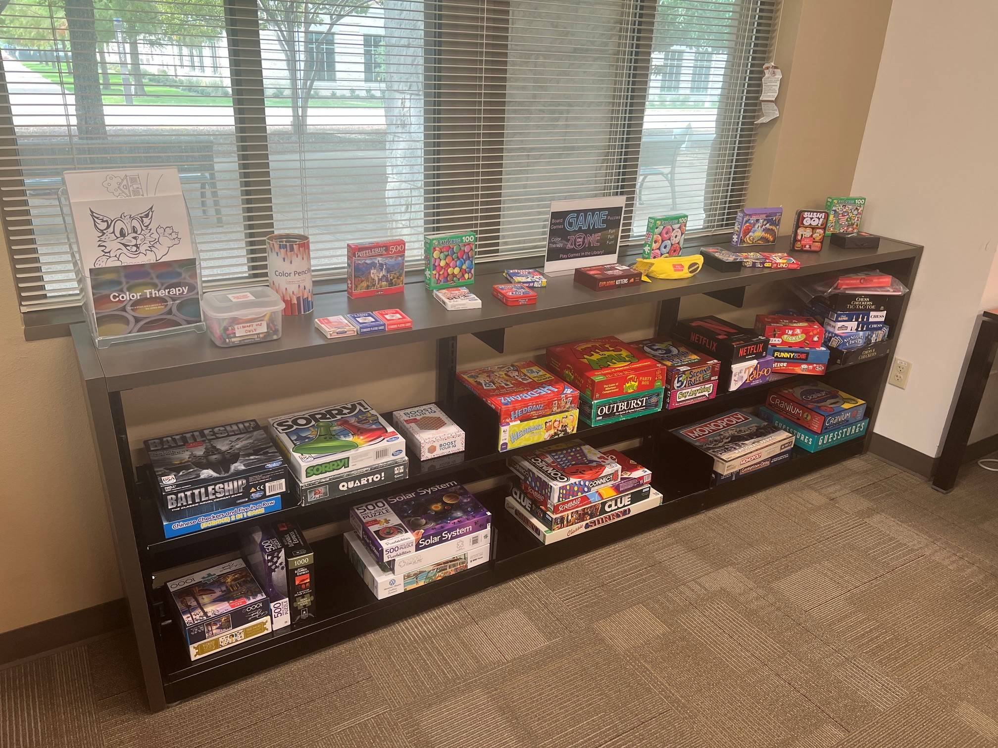 assorted board games on top of a book case