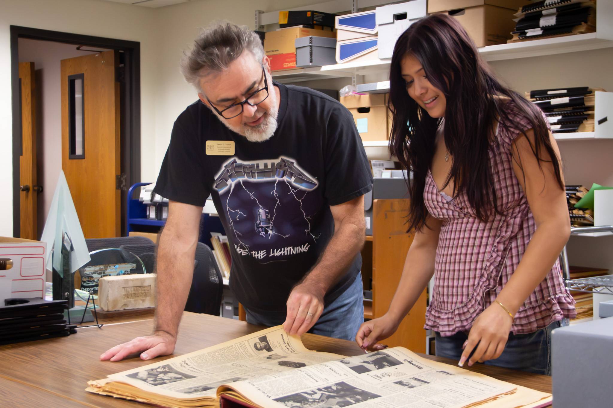 Archivist Jason Crouch reviews historical TXST material with student in the Special Collections & Archives Reading Room.