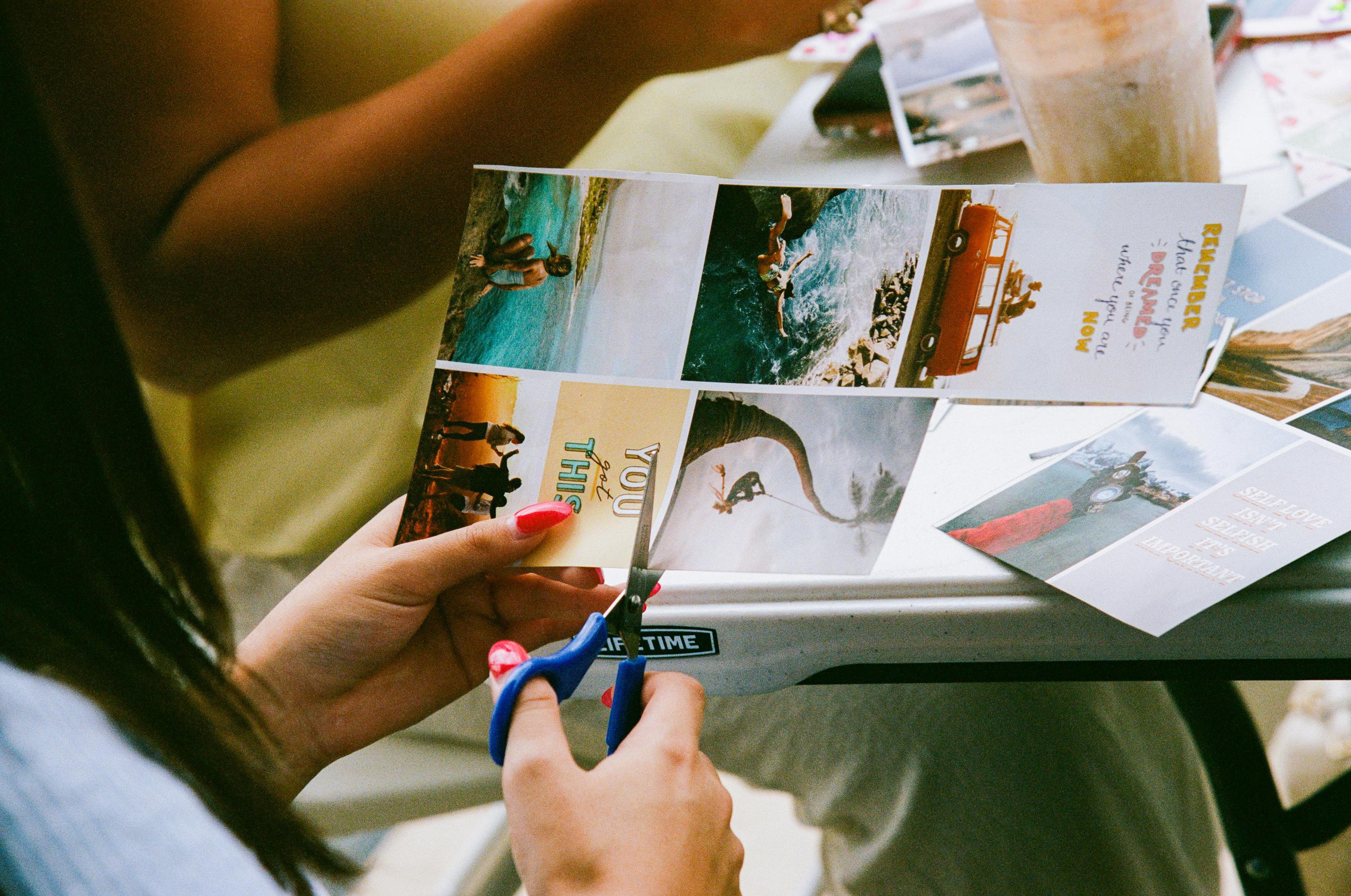 close up of a woman's hands cutting a photo from a piece of paper