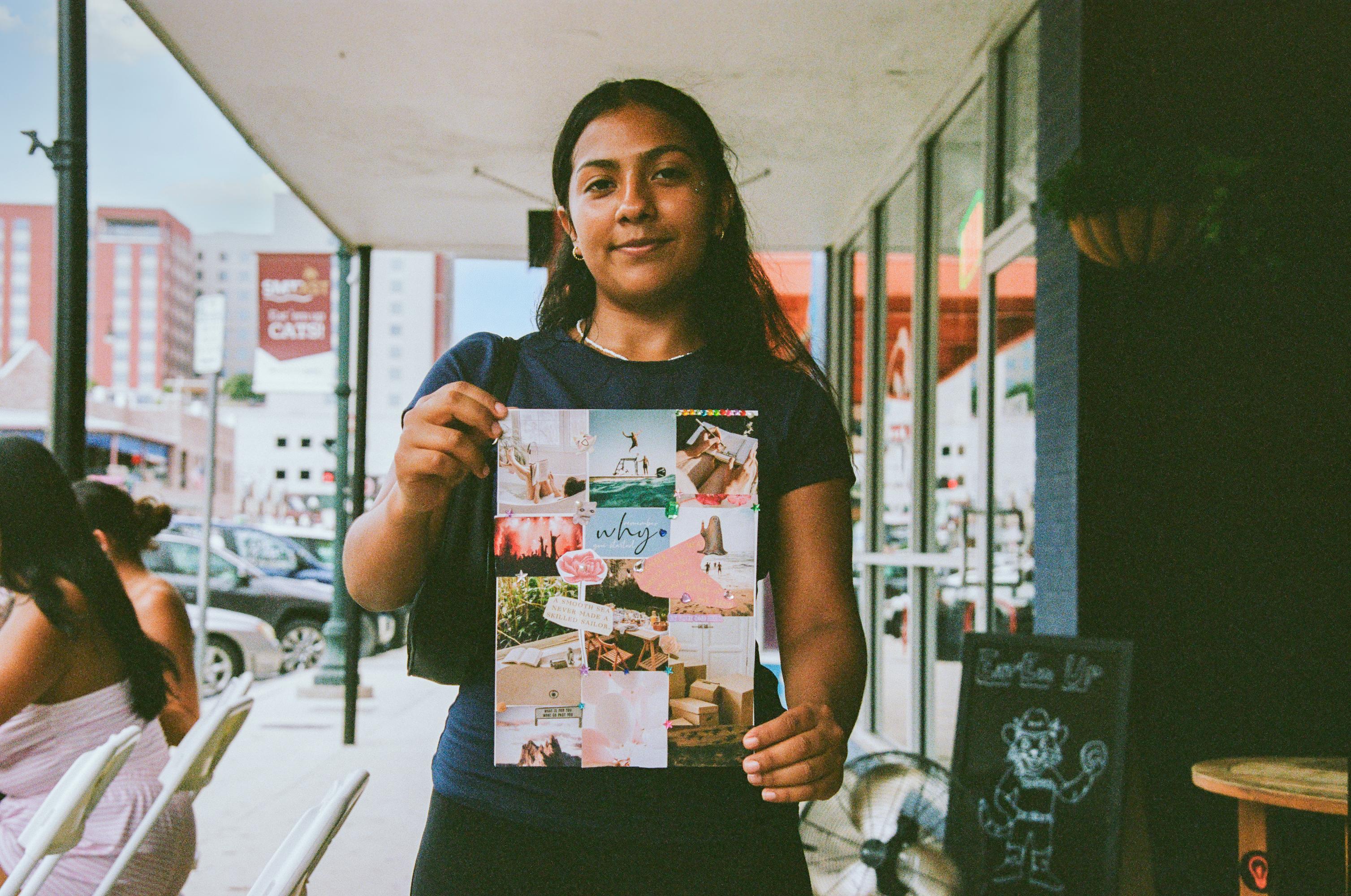 woman holding up a collage she made during a scrapbooking session with friends