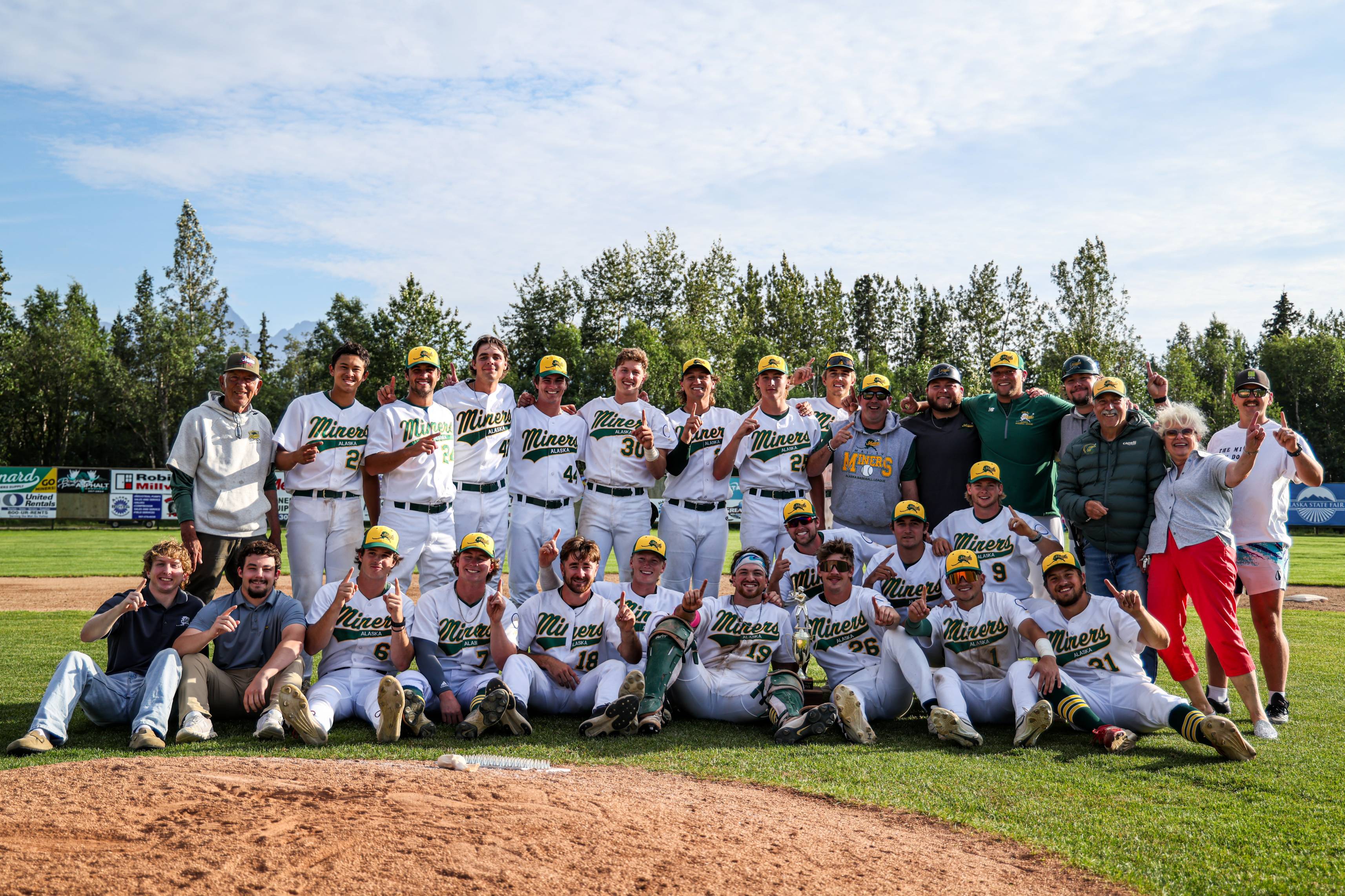 baseball team group photo. they are wearing white and green uniforms.