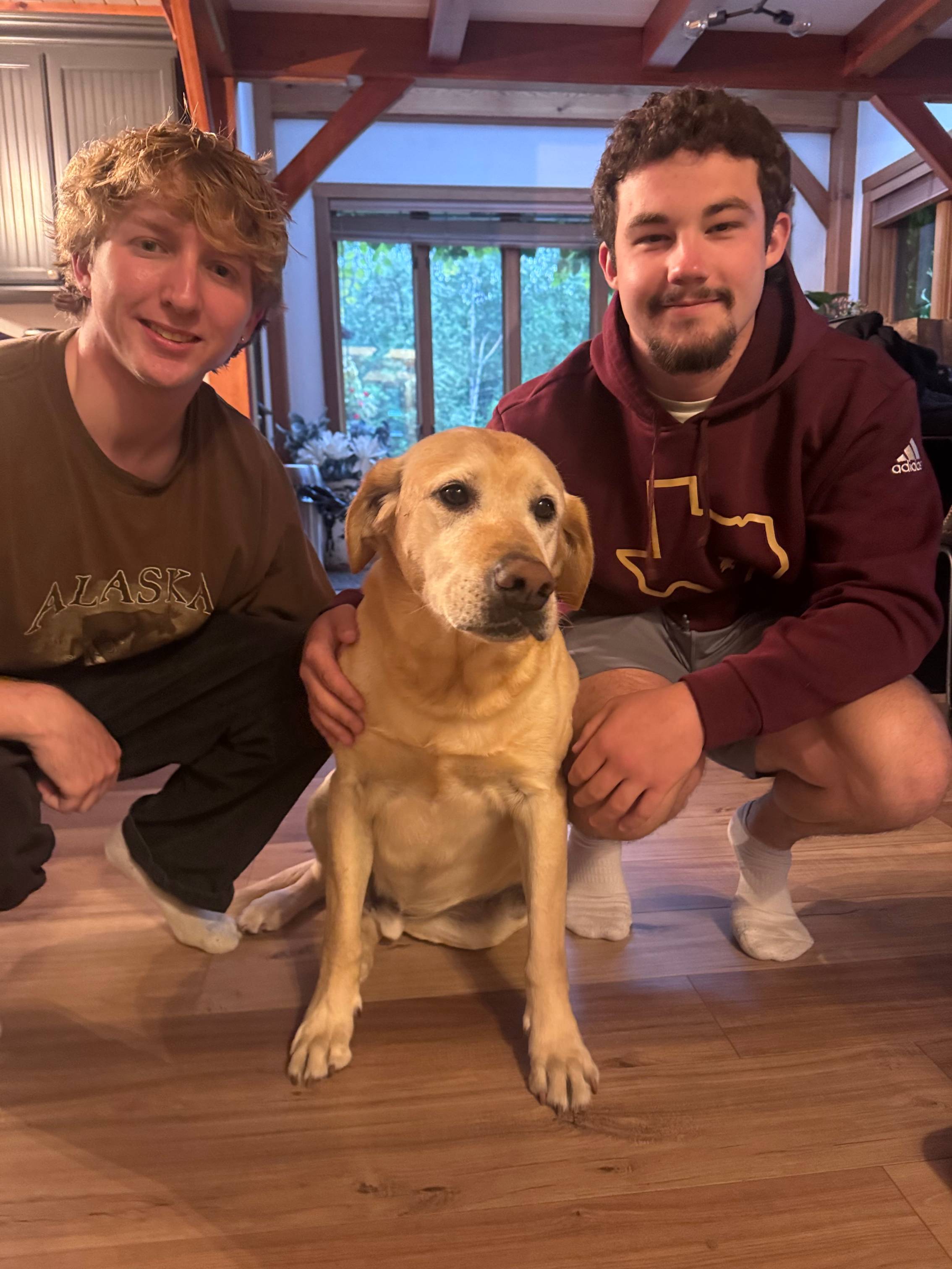 two men squatting to pose wtih golden lab