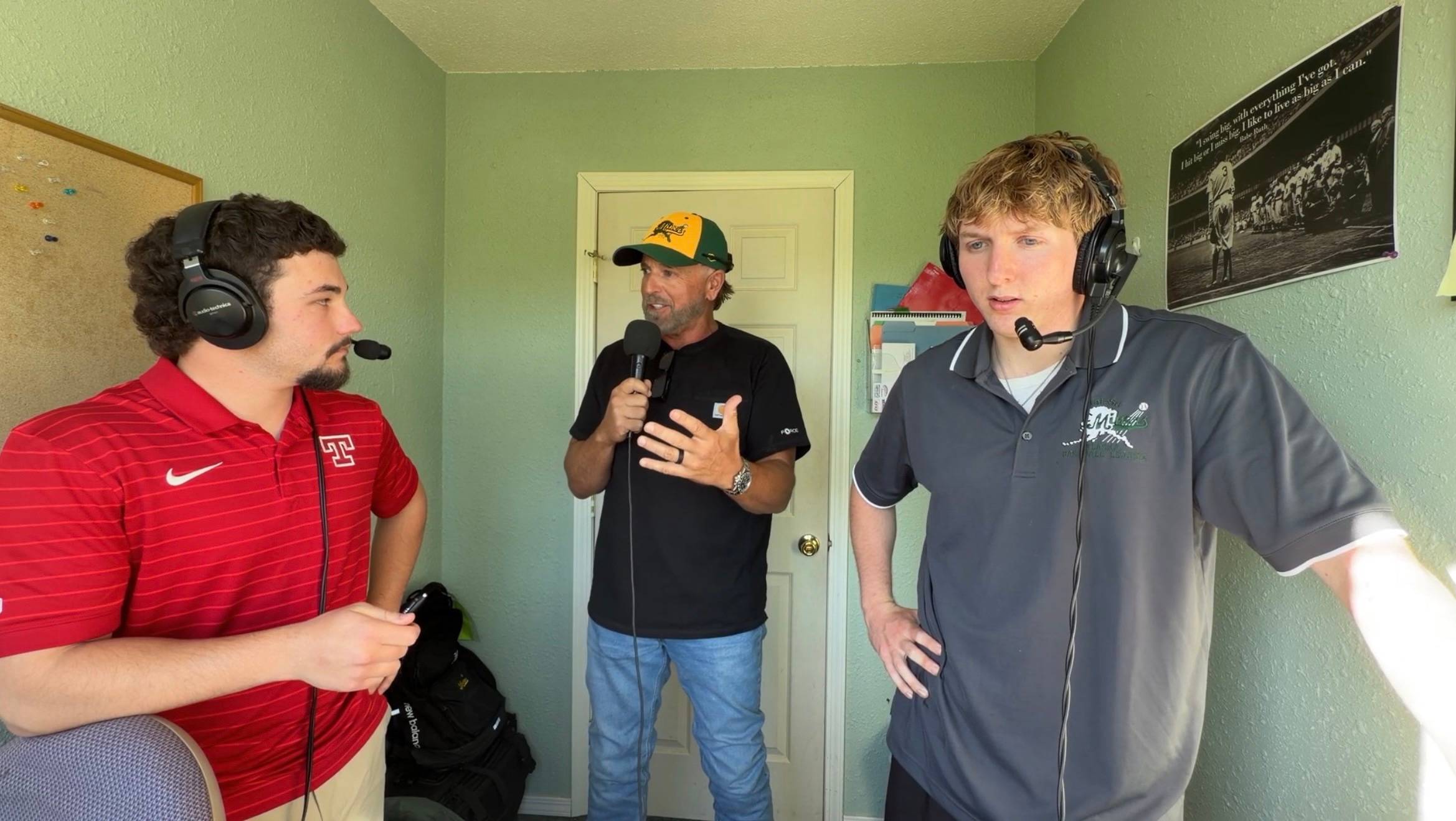 three men in a light green room wearing headsets during while broadcasting a baseball game