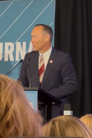 man in suit speaking at podium