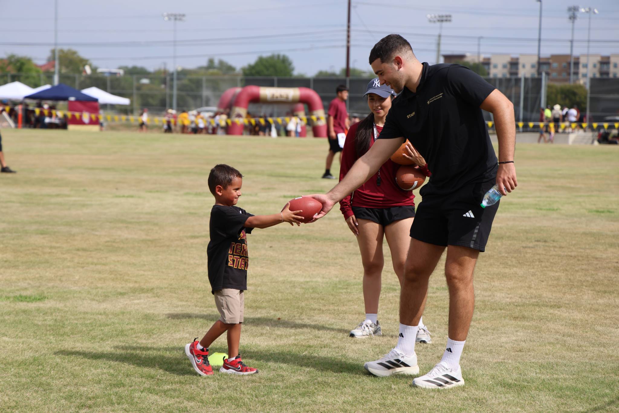 Child playing football at family tailgate