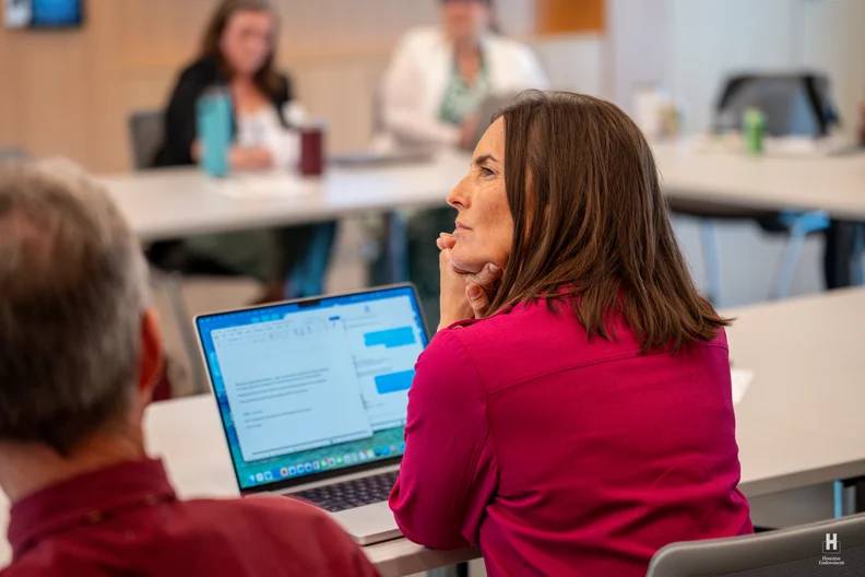 Dr. Minda Lopez glances to the side while on her laptop