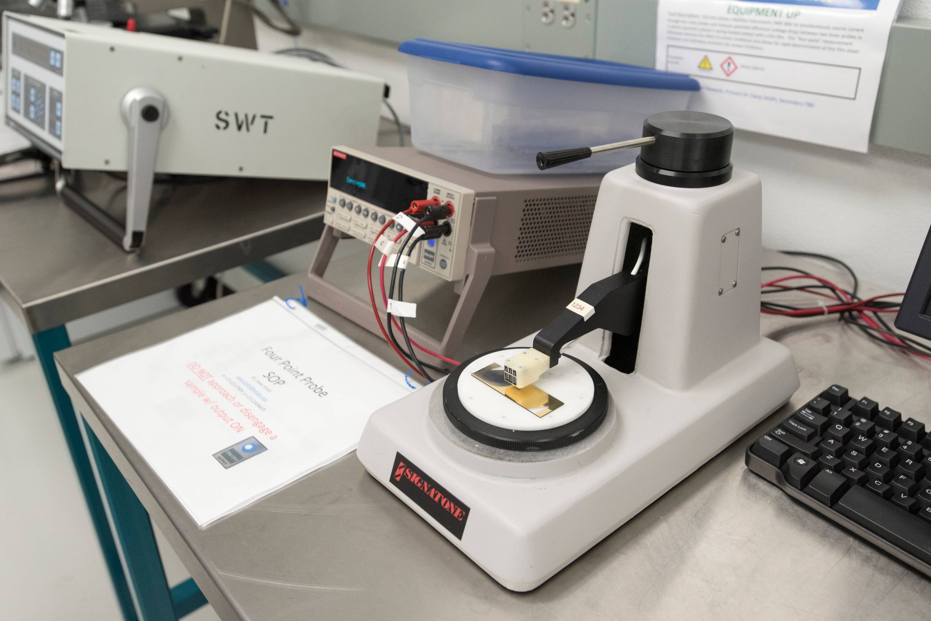 Laboratory probe station testing a small electronic sample.