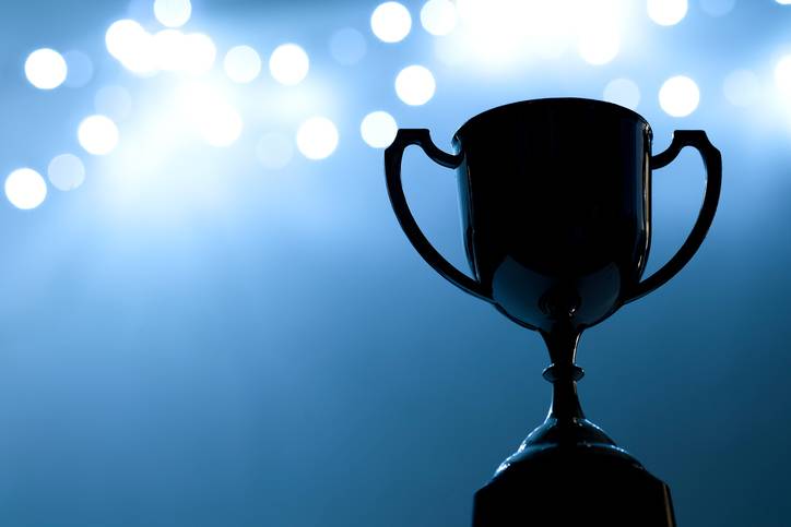 Image of a trophy with a blue background with light boke.