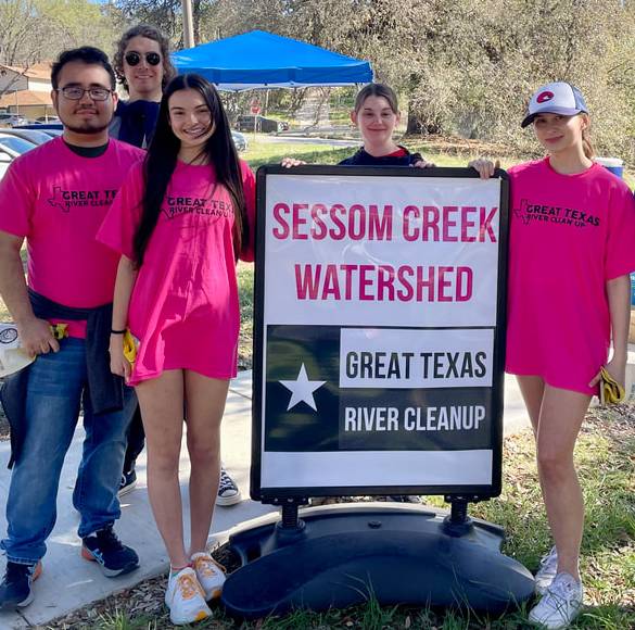 Student volunteers in pink t-shirts at river cleanup