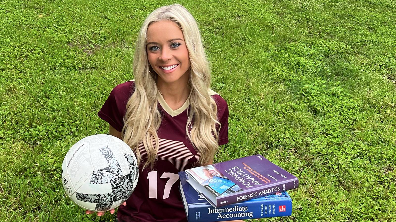 Student soccer player Bailey Peschel holding soccer ball and books