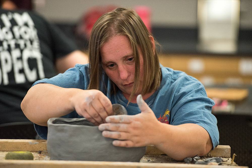 Undergraduate Student working with clay