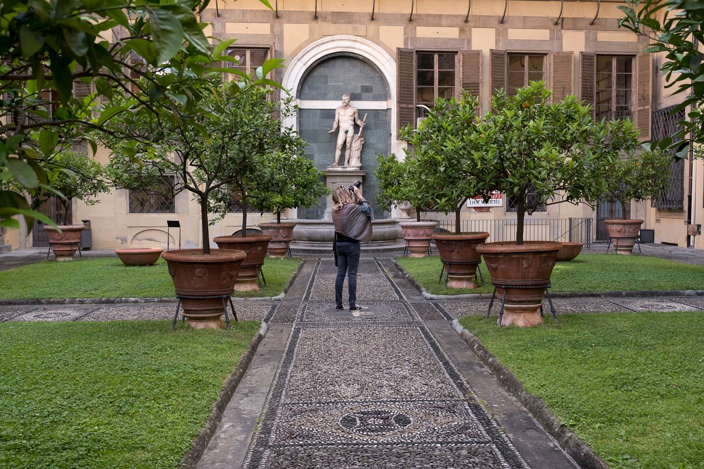 A woman taking a photo in a courtyard